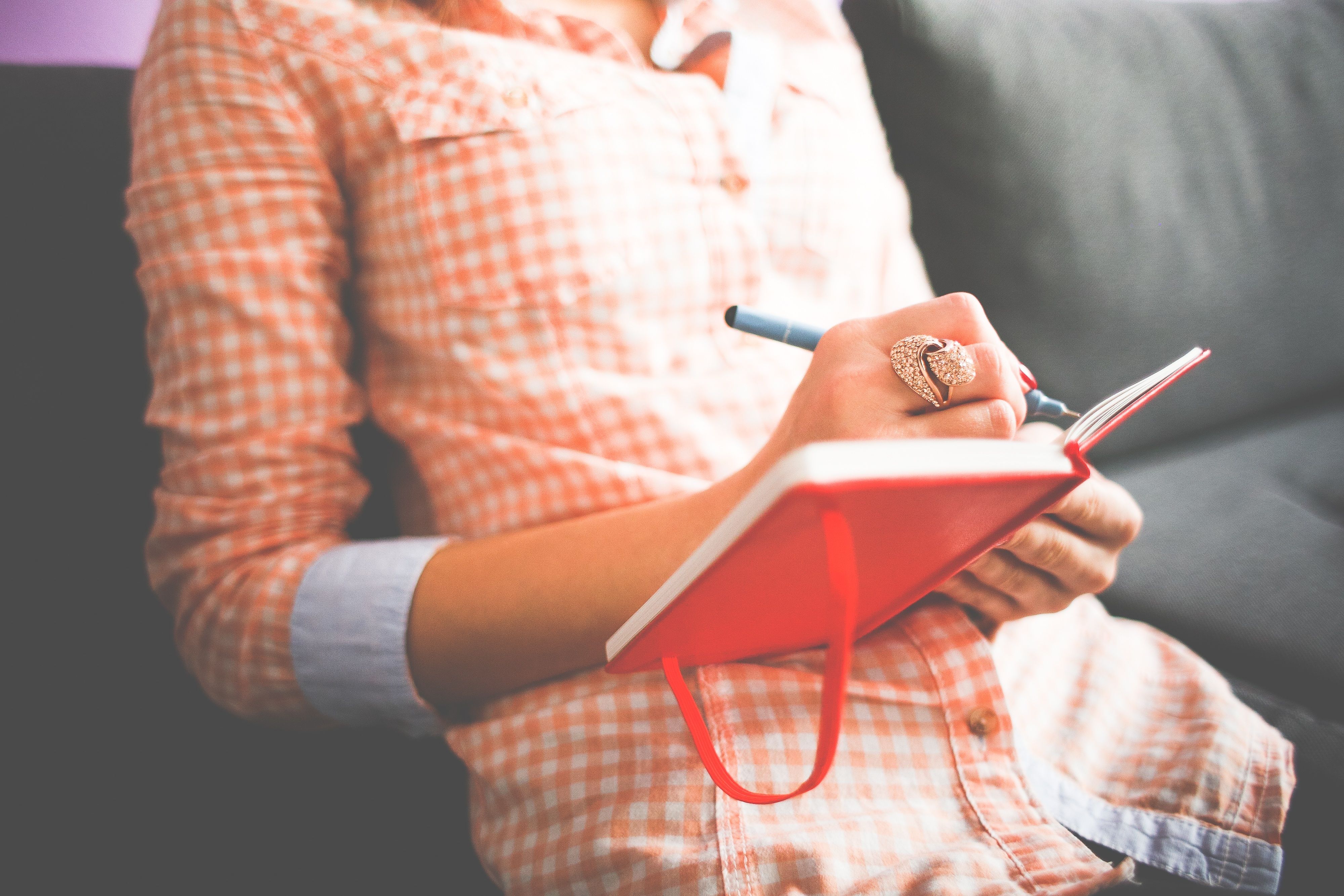 Woman writing in a journal to reflect on her personal boundaries and priorities